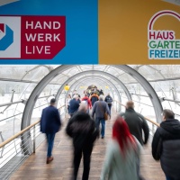 Menschen gehen von der Glashalle in die einzelnen Hallen der Messen HAUS-GARTEN-FREIZEIT und HANDWERK live.