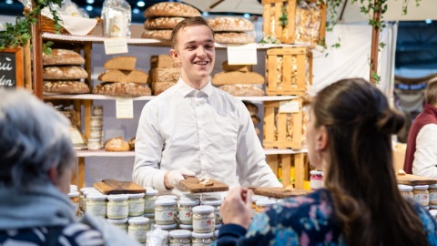 Ein Junger Bäcker verkauft Waren an seinem Stand.