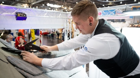 Ein Handwerker arbeitet auf einem Dach.