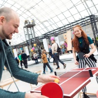 2 Personen spielen auf einer kleinen Tischtennisplatte Tischtennis.