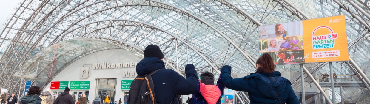 A family walks towards the entrance to the glass hall.