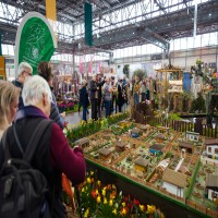 Besucher schauen sich den Miniatur Nachbau eines Kleingarten an. Besucher schauen sich den Miniatur Nachbau eines Kleingarten an.